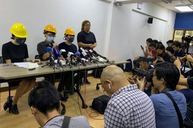 Conférence de presse de trois membres du mouvement pro-démocratie, le visage couvert par un masque, le 6 août 2019 à Hong Kong [Vanessa YUNG / AFP]
