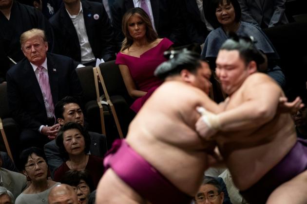 Donald Trump (G), son épouse Melania Trump (C) et le Premier ministre japonais Shinzo Abe (D) assistent à un tournoi de sumo à Tokyo le 26 mai 2019 [Brendan SMIALOWSKI / AFP]