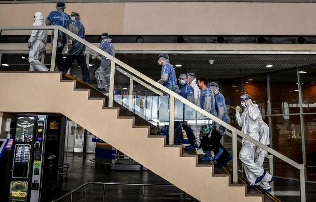 Des membres du personnel aéroportuaire équipés de combinaisons de protection et de masques à l'aéroport Sheremetyevo de Moscou, le 4 avril 2020    [Yuri KADOBNOV / AFP]
