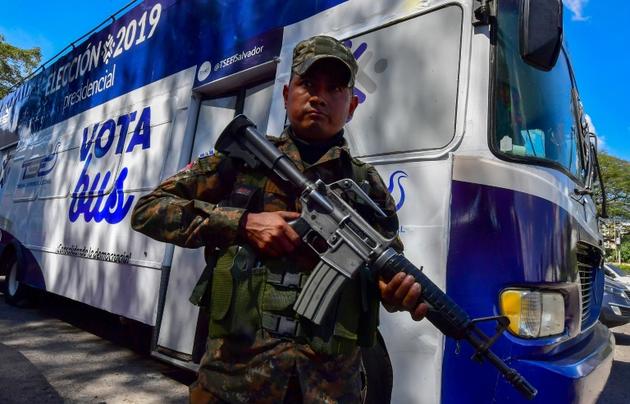 Un soldat salvadorien devant un "Vota bus", chargé d'informer les citoyens sur le scrutin, le 2 février 2019 à San Salvador [Luis ACOSTA / AFP]