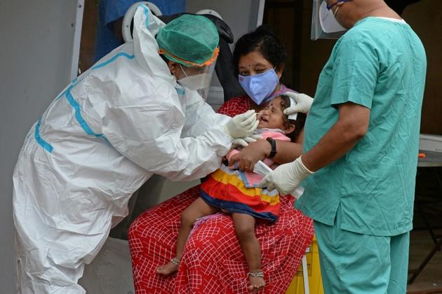 Un personnel de santé effectue un prélèvement sur une enfant dans un centre de test, le 19 août 2020 à Hyderabad, en Inde [NOAH SEELAM / AFP]