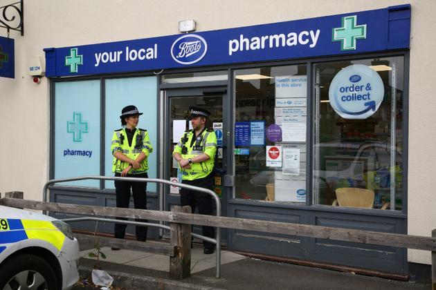 Des policiers en faction le 4 juillet 2018 devant une pharmacie d'Amesbury, ville du sud de l'Angleterre où a été retrouvé inconscient un couple victime d'une exposition  présumée à une "susbstance inconnue"<br />
 [Geoff CADDICK / AFP]