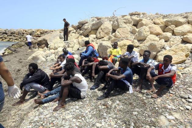 Des rescapés du naufrage d'une embarcation de migrants au large de la Libye arrivent dans la ville côtière libyenne d'al-Hmidiya, le 29 juin 2018 [Mahmud TURKIA / AFP]