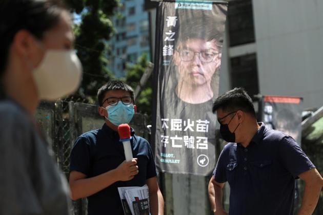 Le militant pro-démocratie Joshua Wong (C), candidat pour les primaires organisées par son camp, durant le scrutin à Hong Kong le 11 juillet 2020 [May JAMES / May James/AFP]