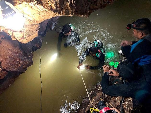 Photo fournie le 30 juin 2018 par la marine royale thaïlandaise de plongeurs inspectant une galerie remplie d'eau dans la grotte de Tham Luang où sont piégés 12 enfants et leur entraîneur de foot [Handout / ROYAL THAI NAVY SEAL/AFP]