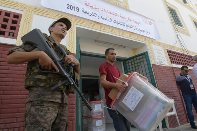 Un membre de l'instance chargée des élections en Tunisie apporte des urnes dans un bureau de vote à la veille du scrutin présidentiel, le 14 septembre 2019 à Tunis [Fethi Belaid / AFP]