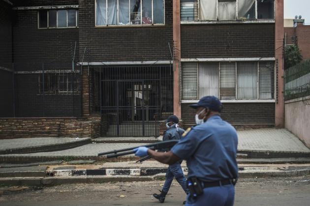 Des policiers tirent des balles en caoutchouc pour disperser plusieurs centaines de personnes faisant la queue devant un supermarché, le 28 mars 2020 à Johannesburg [MARCO LONGARI / AFP]