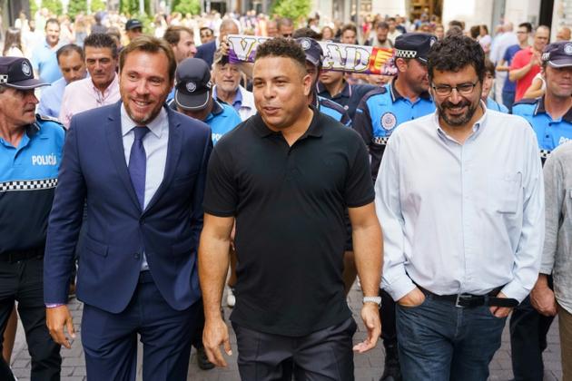 L'ancien attaquant brésilien Ronaldo (au centre) marche aux côtés du maire de Valladolid Oscar Puente (à gauche) lors d'une visite dans la ville espagnole le 3 septembre 2018 après le rachat par la star brésilienne du club de Valladolid.  [CESAR MANSO / AFP/Archives]