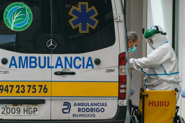 Un membre du personnel soignant aide un homme à descendre d'une ambulance à l'hôpital de Burgos, dans le nord de l'Espagne, le 23 mars 2020 [CESAR MANSO / AFP]
