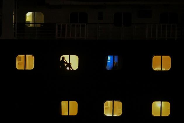 Des passagers du Zaandam dans leur cabine tandis que le navire traverse le canal du Panama, le 29 mars 2020 [Luis ACOSTA / AFP]