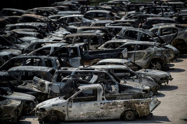 Des voitures calcinées, à Rafina, près d'Athènes, le 26 juillet 2018 [ANGELOS TZORTZINIS / AFP]