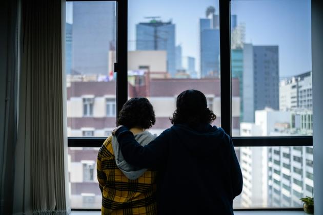 Deux jeunes soeurs saoudiennes ayant fui à l'étranger regardent par une fenêtre à Hong Kong, le 22 février 2019 [Anthony WALLACE / AFP/Archives]