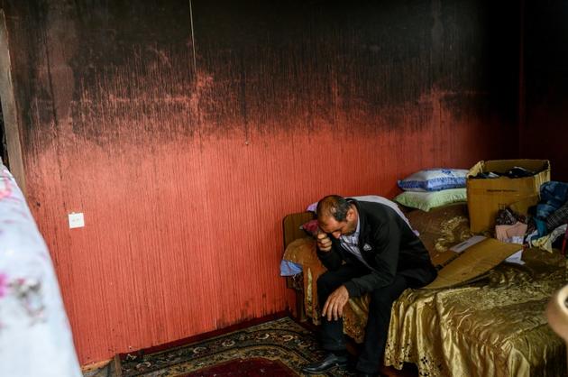 Un homme dans la chambre de son appartement, incendié et détruit par un bombardement, le 10 octobre 2020 à Tartar, en Azerbaïdjan [Bulent Kilic / AFP]