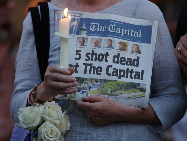 Une femme tient le journal le Capital le 29 juin 2018, au lendemain de la fusillade au quotidien ayant fait cinq morts à Annapolis, dans le Maryland   [MARK WILSON / GETTY IMAGES NORTH AMERICA/AFP/Archives]