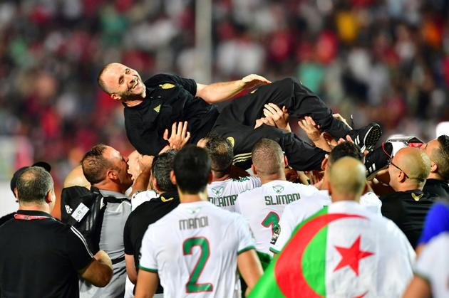 Le sélectionneur de l'Algérie Djamel Belmadi porté par ses joueurs en liesse après la victoire face au Sénégal en finale de la CAN-2019, le 19 juillet 2019 au Caire [Giuseppe CACACE / AFP]