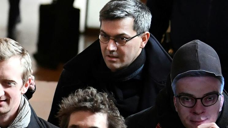 Le chef du groupe dit "de Tarnac" Julien Coupat arrive au procès avec une personne portant le masque du procureur Olivier Christen, le 13 mars 2018 [ALAIN JOCARD / AFP/Archives]