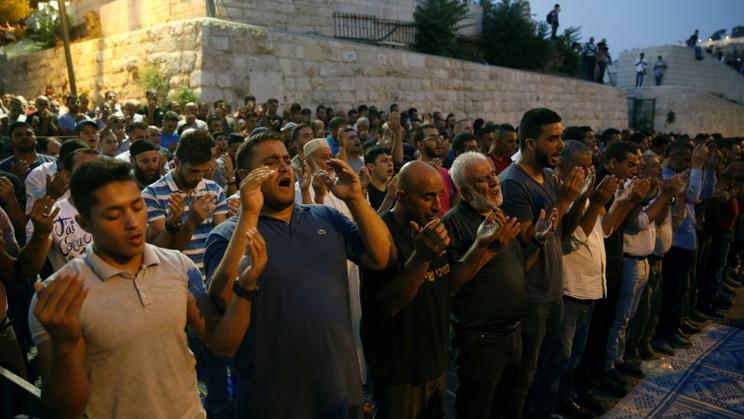 Des palestiniens musulmans prient devant la porte des Lions, à Jérusalem, le 27 juillet 2017 [AHMAD GHARABLI / AFP]