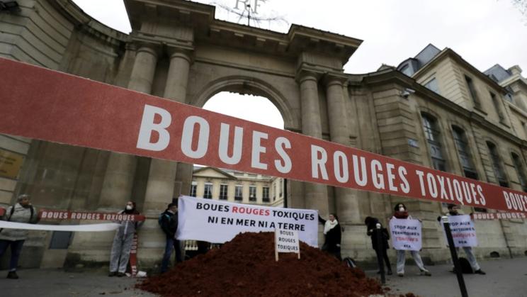 Des activistes déversent de la boue rouge devant le ministère de l'Ecologie le 12 février 2019 à Paris [Thomas SAMSON / AFP]