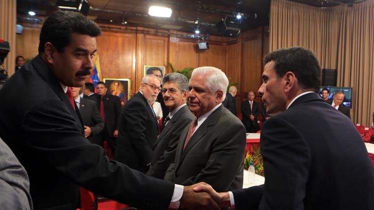 Le président vénézuélien Nicolas Maduro (gauche) salue le leader de l'opposition Henrique Capriles avant un rassemblement le 10 avril 2014 à Caracas [Présidence vénézuélienne / PRESIDENCIA/AFP]