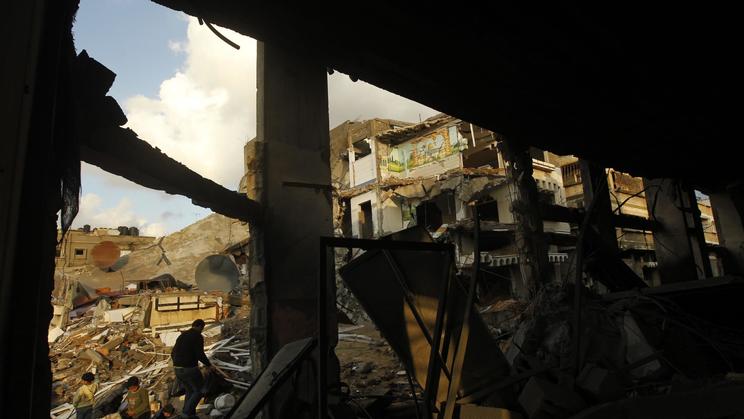 Des Palestiniens inspectent le 23 novembre 2012 les débris d'immeubles détruits par des bombardements en plein centre de Gaza [Mohammed Abed / AFP]
