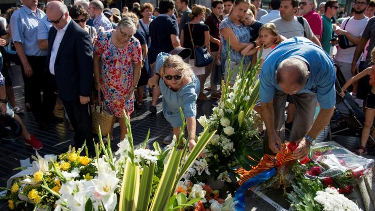 Les passants déposent des fleurs en hommage aux victimes de l'attaque des Ramblas à Barcelone, le 16 août 2018 [Josep LAGO / AFP]