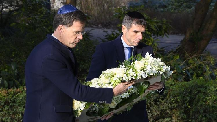 Accompagné d'un secrétaire d'Etat, le Premier ministre néerlandais Mark Rutte (à gauche) a déposé une gerbe de fleurs au pied du monument à la mémoire des victimes d'Auschwitz à Amsterdam. 