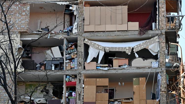 Cette photo montre les dégâts sur un immeuble résidentiel de cinq étages qui s'est partiellement effondré après un bombardement à Kiev, le 18 mars 2022.