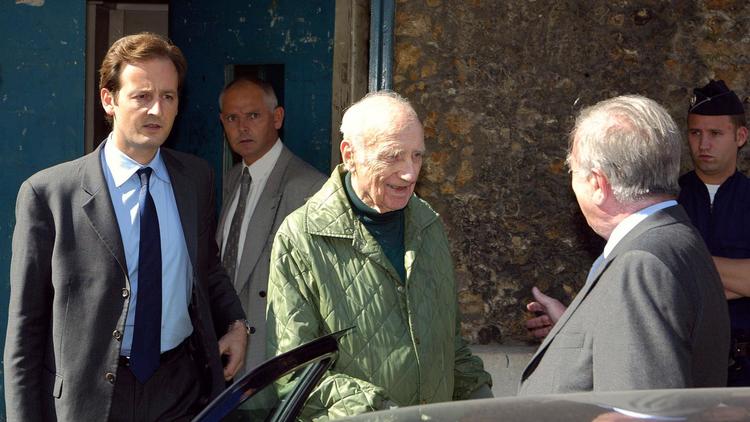 Maurice Papon (c) sort de prison le 18 septembre 2002 à Paris, accueilli par ses avocats, Mes Francis Vuillemin (G) et Jean-Marc Varaut (d) [Jack Guez / AFP/Archives]