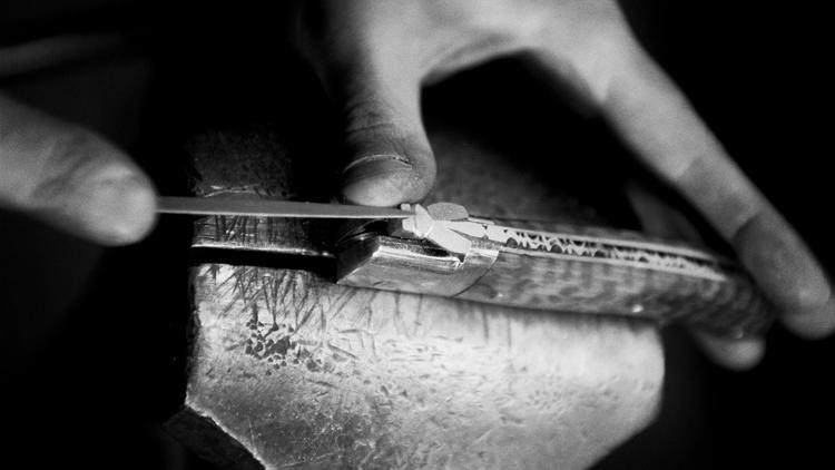Un coutelier guilloche le ressort d'un couteau, le 18 mai 2005 dans la coutellerie Fontenille-Pataud de Thiers. Le guillochage, consiste à limer le ressort d'un couteau, ce qui représente une véritable signature pour les couteliers [Martin Bureau / AFP/Archives]