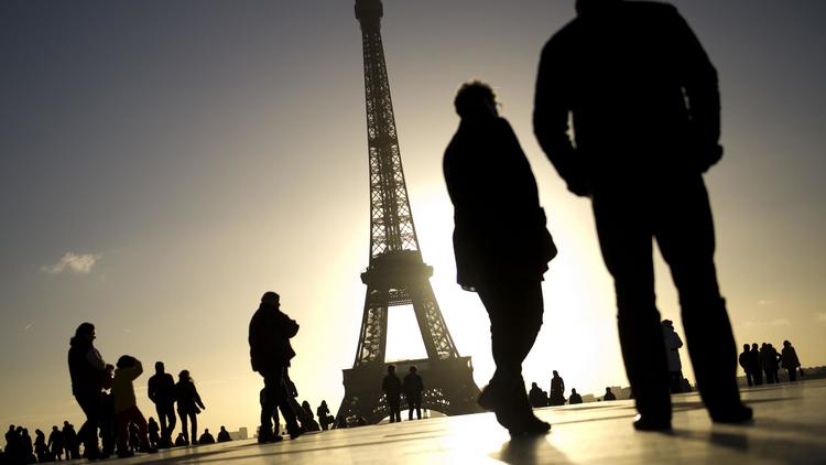 Des passants devant la Tour Eiffel [Lionel Bonaventure / AFP/Archives]