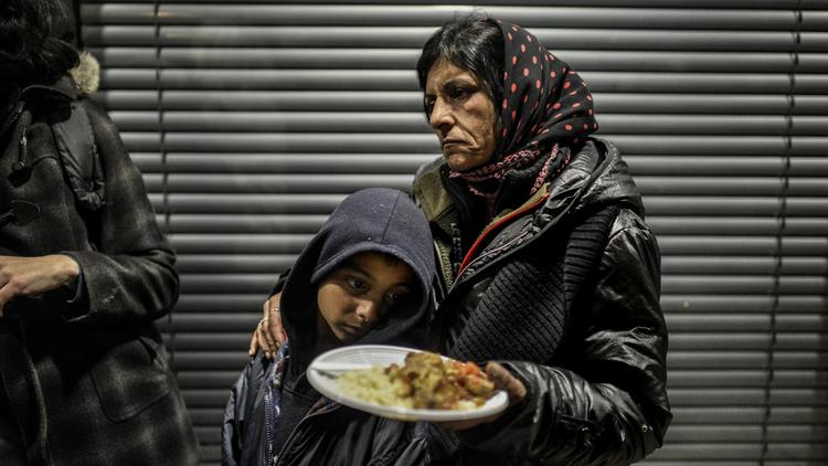 Des Roms, expulsés de leur campement, sont nourris le 3 avril 2013 devant le tribunal  administratif de Lyon alors qu'ils attendent une décision de la justice sur leur éventuellement relogement [Jeff Pachoud / AFP]
