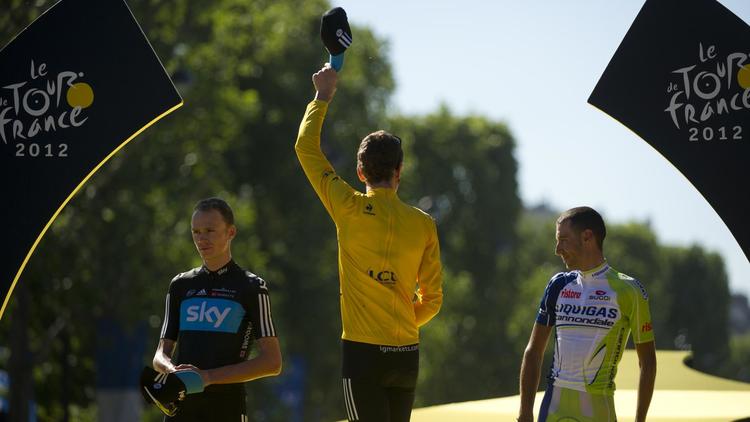Le Britannique Bradley Wiggins (C) sur le podium du Tour de France 2012, entouré de ses dauphins Christopher Froome (G) et Vincenzo Nibali, le 22 juillet 2012 à Paris [ / AFP]