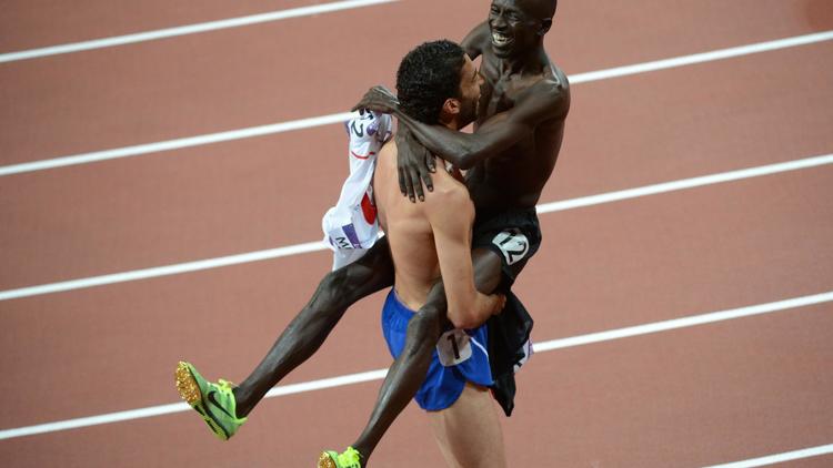 Accolade entre le champion olympique du 3000 m steeple Ezekiel Kemboi et son dauphin Mahiédine Mekhissi, à l'issue de la finale aux JO, le 5 août 2012. [Christophe Simon / AFP/Archives]