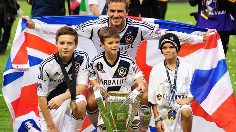 David Beckham entouré de ses trois fils (de g à d) Brooklyn, Cruz et Romeo, après avoir remporté la finale de la MLS avec son club de Los Angeles Galaxy, le 1er décembre 2012. [Robyn Beck / AFP/Archives]