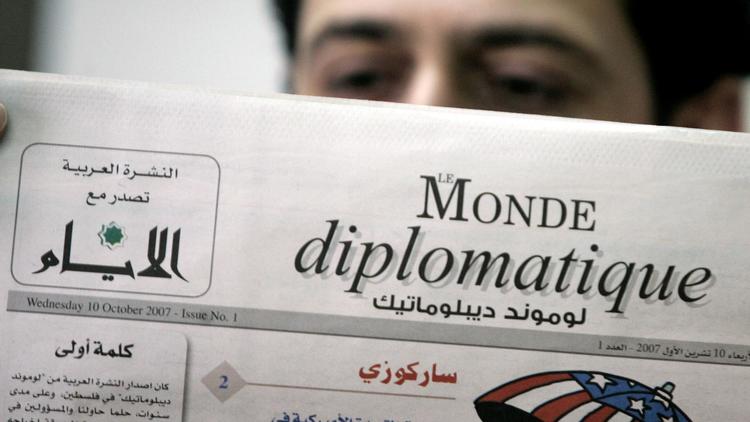 Un homme lit le Monde Diplomatique [Abbas Momani / AFP/Archives]