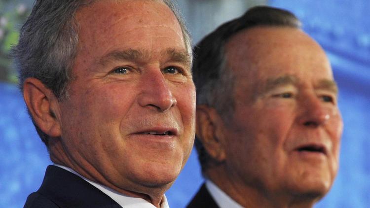 George W. Bush, à gauche, et son père George H. W., à Pékin, le 8 août 2008 [Mandel Ngan / AFP/Archives]