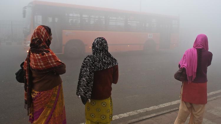Des femmes attendent un bus dans un nuage de pollution, le 31 janvier 2013 à New Delhi [Prakash Singh / AFP/Archives]