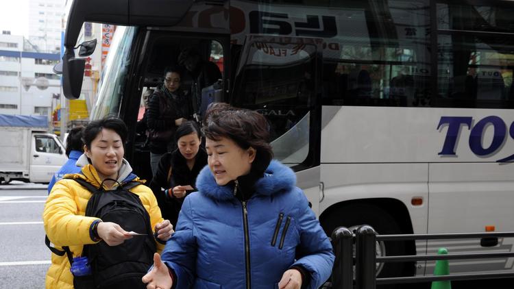 Des touristes chinoises descendent d'un bus à Tokyo [Toshifumi Kitamura / AFP/Archives]