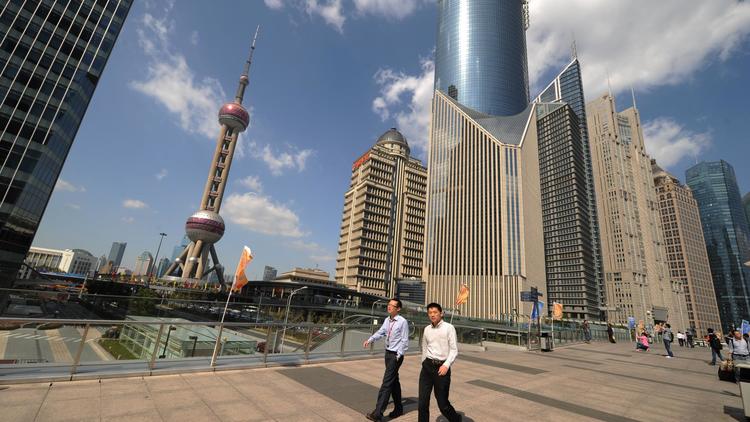Deux hommes marchent dans le quartier d'affaires de Shanghai, le 17 oct8bre 2012 [Peter Parks / AFP/Archives]