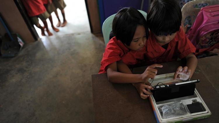 Des écolières utilisent une tablette à l'école Ban San Kong de Mae Chan, en Thaïlande, le 27 mai 2013 [Christophe Archambault / AFP]