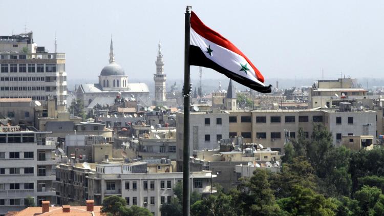 Le drapeau syrien flotte sur Damas [Louai Beshara / AFP/Archives]