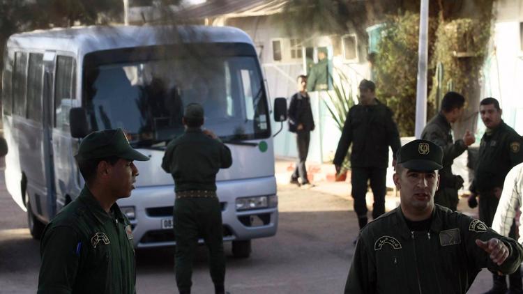 Un bus transportant des otages libérés du site gazier entouré de membres des forces de sécurité algériennes le 19 janvier 2013 à d'In Amenas