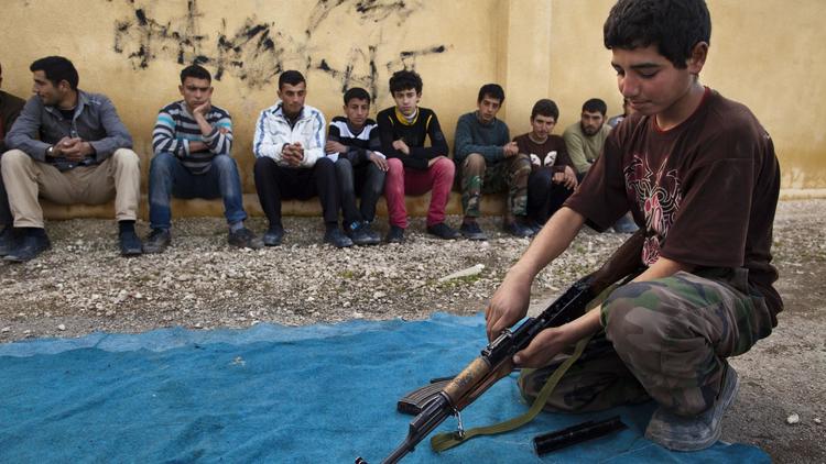 Un jeune syrien manipule le 23 janvier 2013 un fusil AK-47   lors d'un entraînement militaire dans la province d'Alep, au nord du pays [Jm Lopez / AFP/Archives]