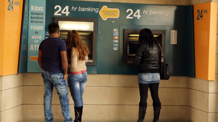 Des personnes retirent de l'argent dans un distributeur de la Bank of Cyprus à Nicosie, le 8 avril 2013 [Patrick Baz / AFP]