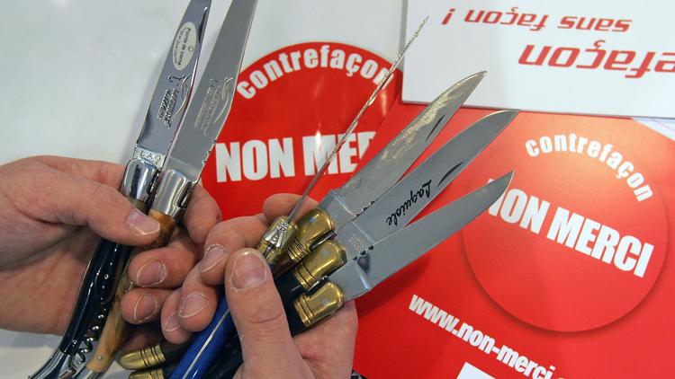 Photo datant de 2006 montrant deux couteaux Laguiole (g) présentés à côté de quatre couteaux contrefaits en Chine et au Pakistan [Eric Cabanis / AFP/Archives]