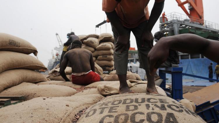 Des ouvriers vident des sacs de cacao ivoirien le 18 janvier 2011 dans le Port d'Abidjan [Issouf Sanogo / AFP/Archives]