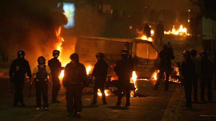 Des policiers devant des véhicules incendiés le 28 octobre 2005 à Clichy-sous-Bois. [Joel Saget / AFP/Archives]