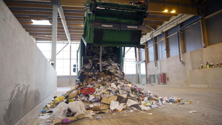Un camion poubelle décharge des déchets dans un centre de tri [Bertrand Langlois / AFP/Archives]