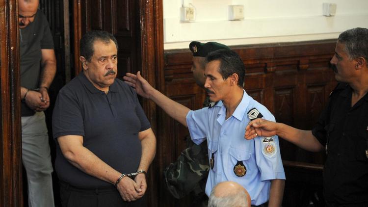 Moncef Trabelsi (2e g) rentre menotté dans le tribunal de Tunis où il sera jugé, le 10 août 2011 [Fethi Belaid / AFP/Archives]