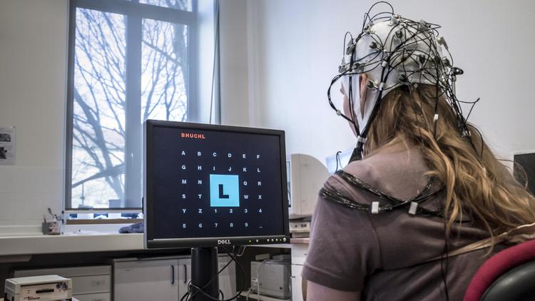 Une jeune femme munie d'un casque à électrodes fait des tests au Centre de recherches neuroscientifiques de Lyon, le 15 mars 12012 [Jean-Philippe Ksiazek / AFP/Archives]